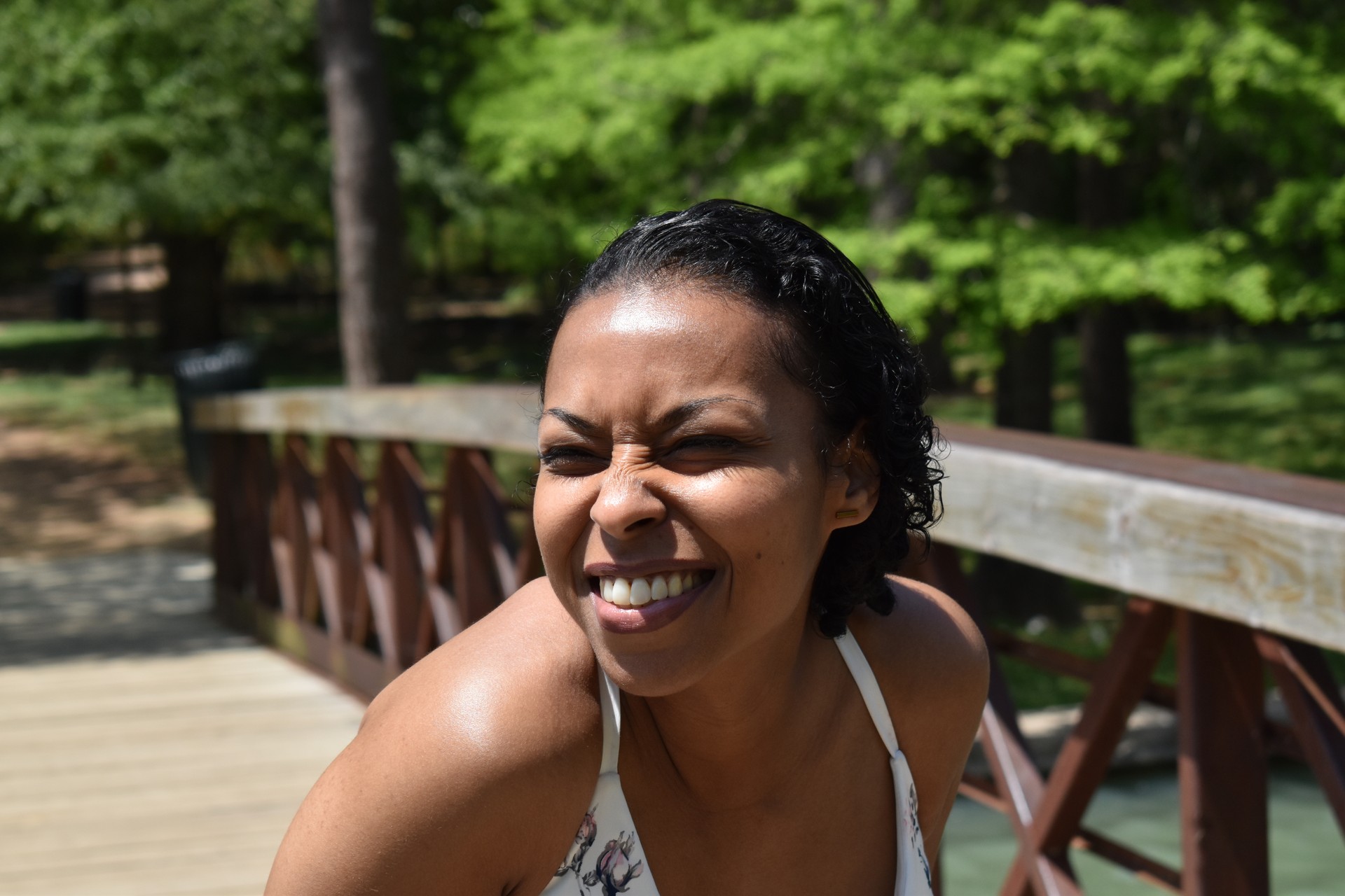 A portrait of a beautiful woman of color a moment of joy while in front of a heavenly landscape and bridge.